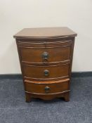 A Victorian style three drawer bedside chest with slide