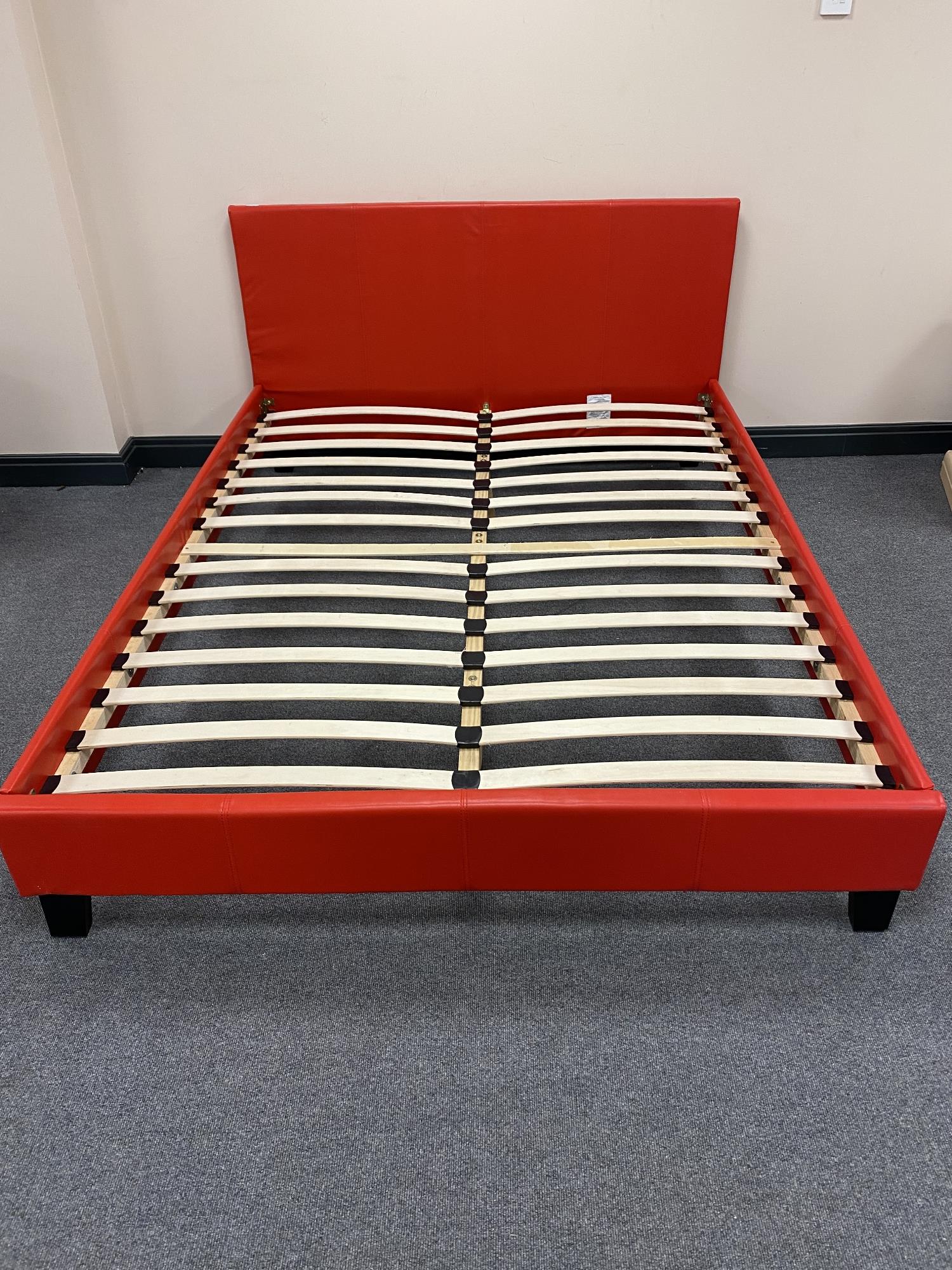 A boxed red faux leather 4'6 bed frame