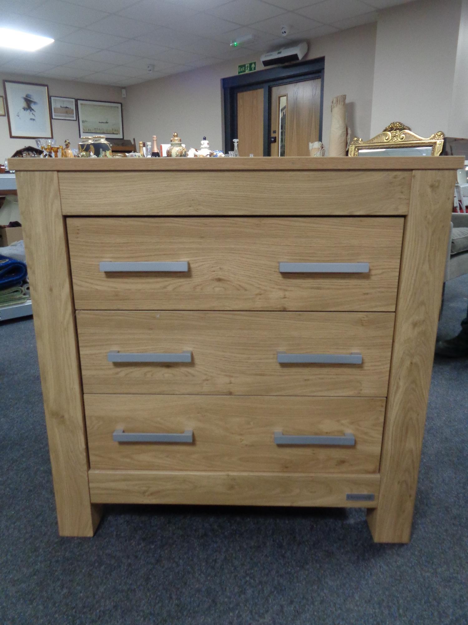 A Charnwood three drawer chest in oak effect finish