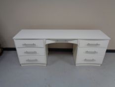 A painted 20th century knee hole desk fitted seven drawers