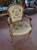 A beech framed French style salon armchair upholstered in a tapestry fabric