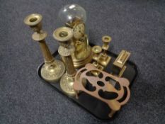 A tray of two pairs of brass candlesticks, trivet, anniversary clock under shade,