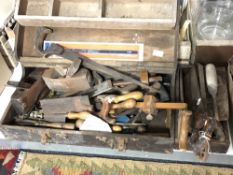 A vintage joiner's tool box and a tool caddy of hand saws, chisels,