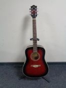 A Deacon six string acoustic guitar on stand