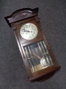 An early 20th century oak cased eight day wall clock with silvered dial,