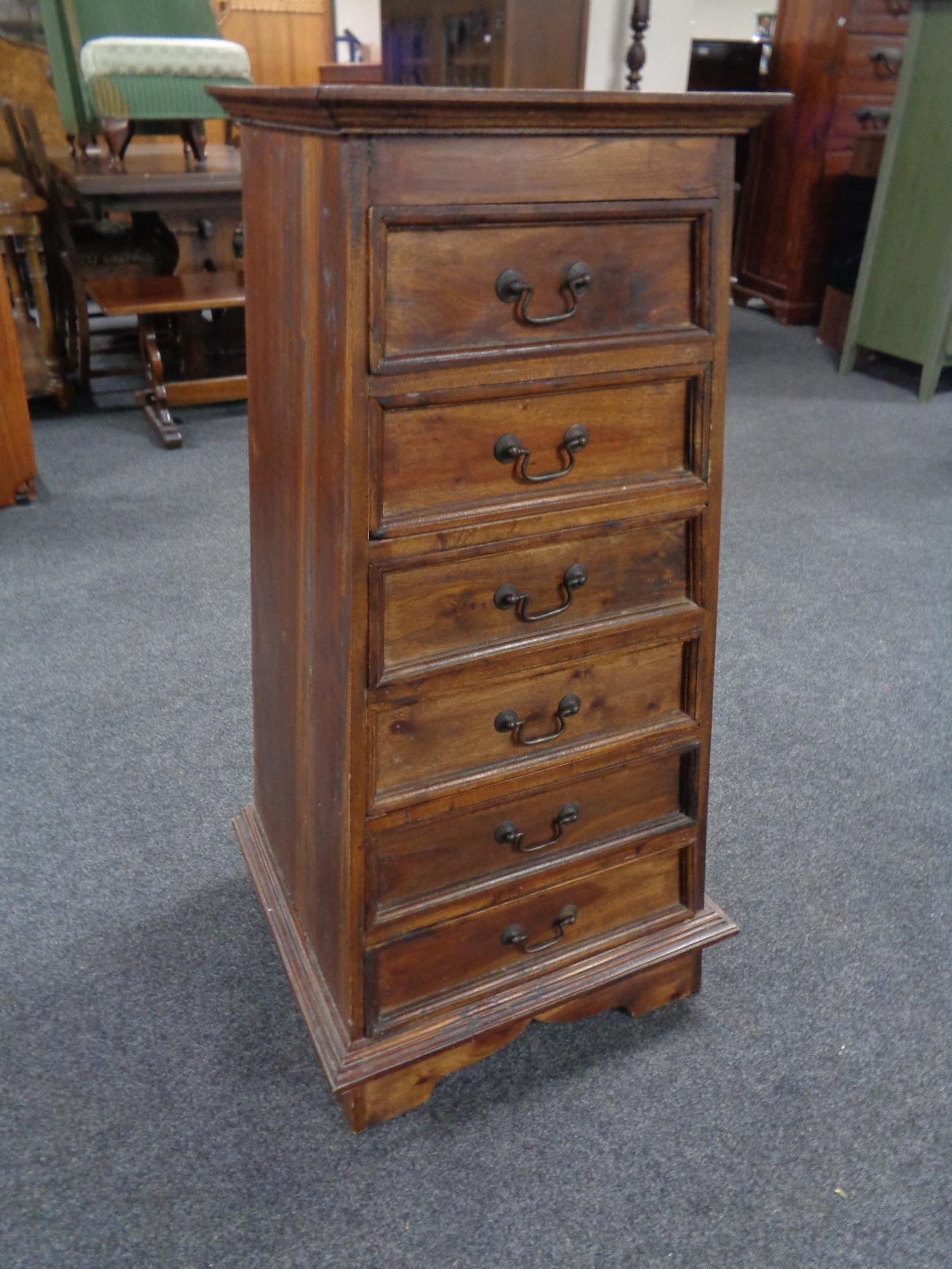 A sheesham wood six drawer tapered chest with metal drop handles,