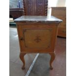 A 20th century pine marble topped bedside cabinet