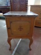 A 20th century pine marble topped bedside cabinet
