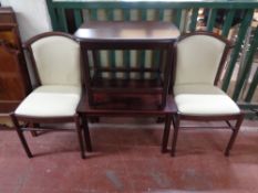 A pair of stained beech armchairs together with two coffee tables