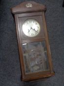 An early 20th century oak cased eight day wall clock with silvered dial,