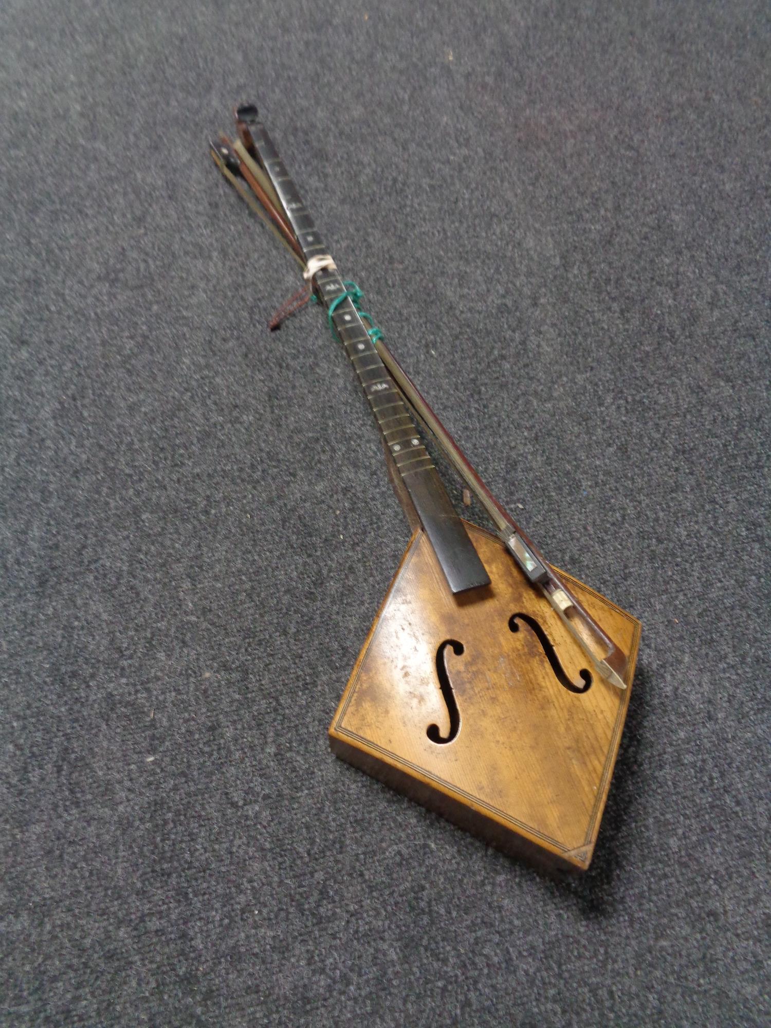 A late 19th century single stringed instrument with bows,