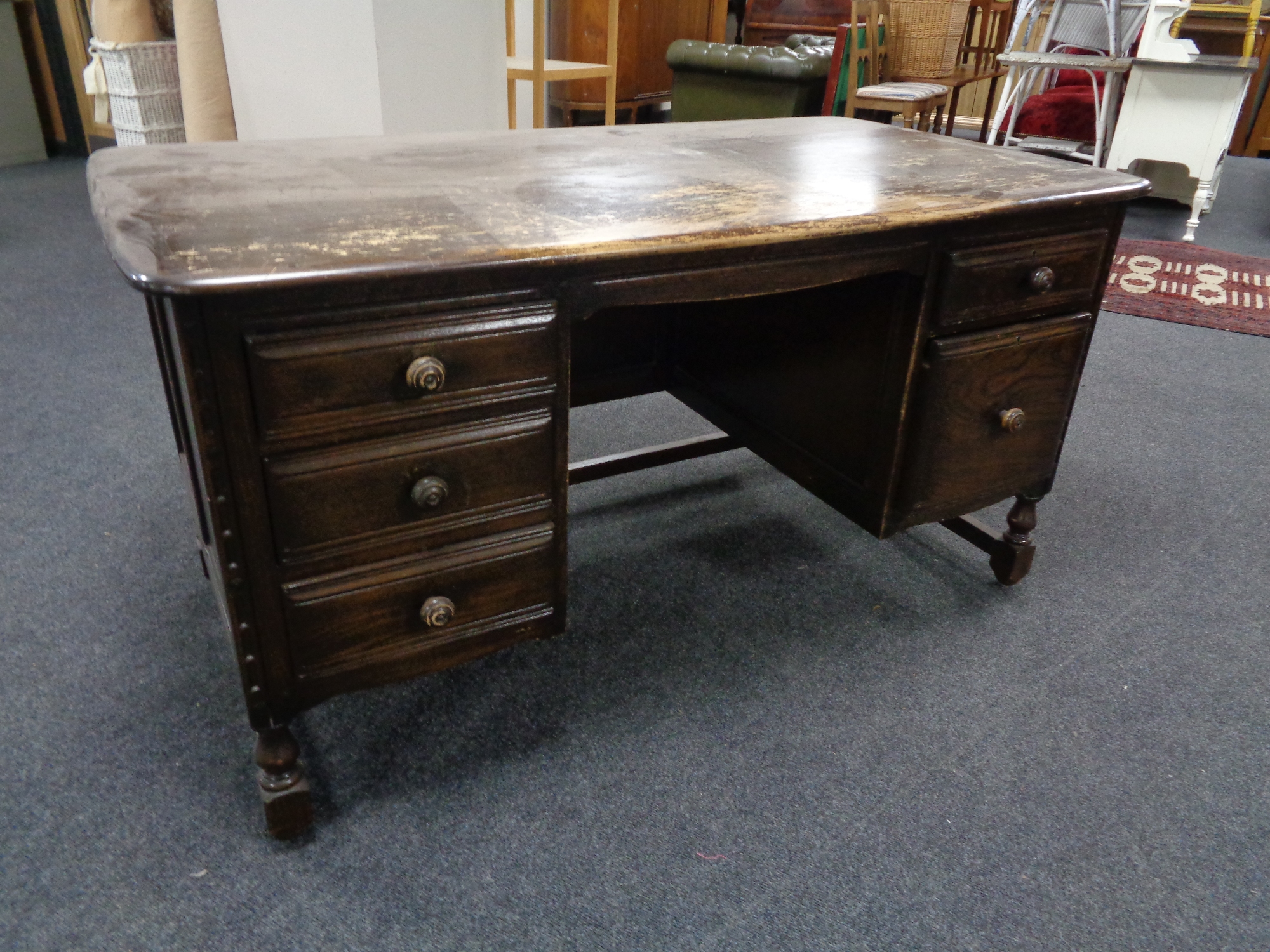 An Ercol twin pedestal writing desk fitted five drawers
