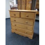 A stripped pine five drawer chest with knob handles