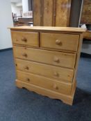 A stripped pine five drawer chest with knob handles