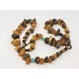 A bead necklace strung with unpolished amber and other stones, length approx.