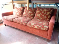 A contemporary three seater settee upholstered in a red floral fabric