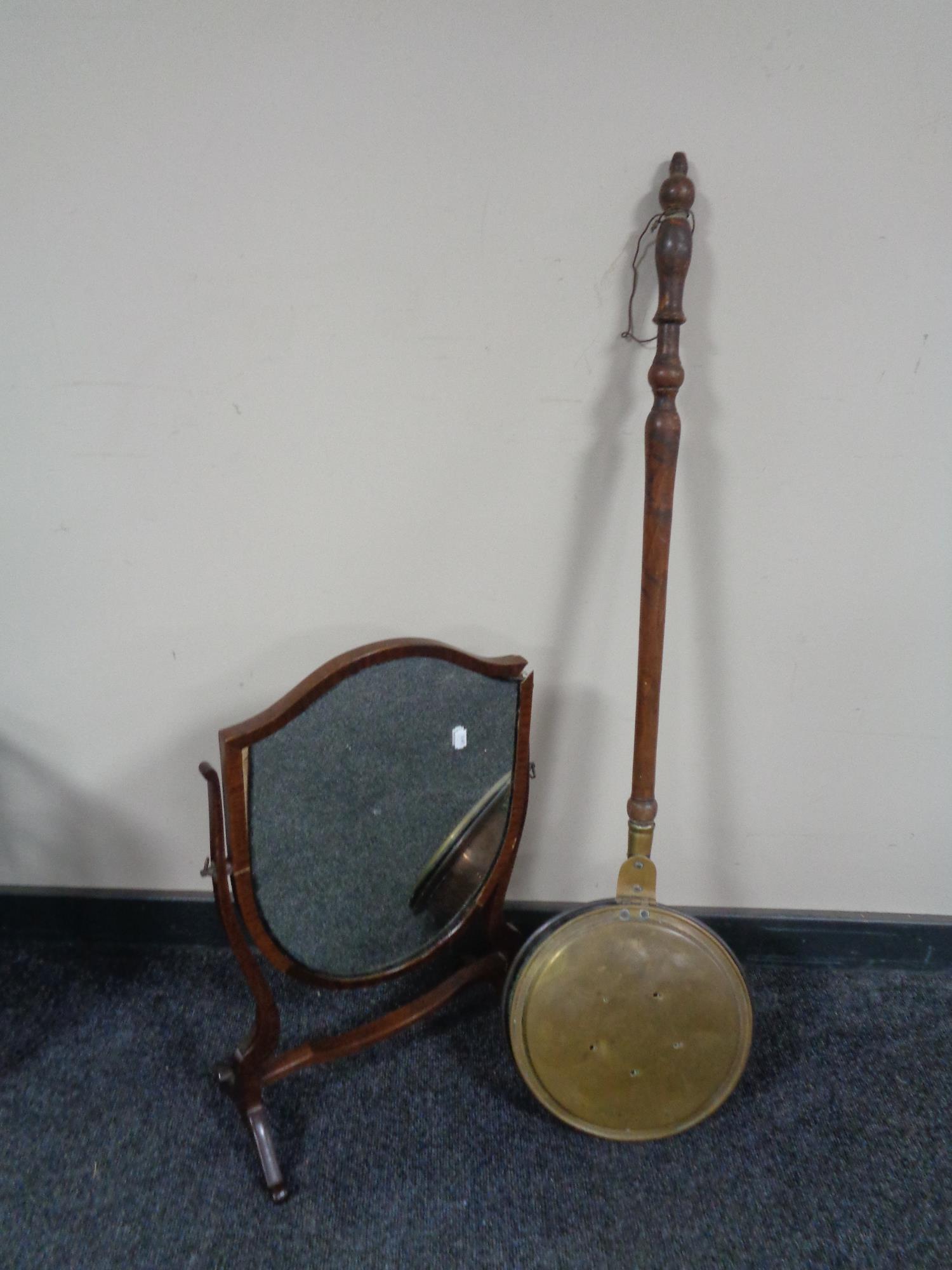 An Edwardian mahogany shield dressing table mirror and a bed warming pan