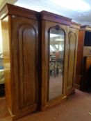 A Victorian mahogany triple door break-front wardrobe with mirrored central door and later pine