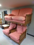 An Ercol wood framed three piece bergere suite with pink cushions