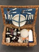 A fitted wicker picnic hamper by Optima of Storrington containing china, cutlery, picnic blanket,