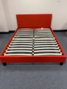 A boxed red faux leather 4'6 bed frame