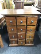 A sheesham wood twelve drawer chest with metal drop handles