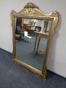 An ornate gilt bevelled overmantel mirror