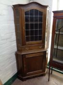A 20th century century continental oak corner cabinet with leaded glass door fitted drawer and