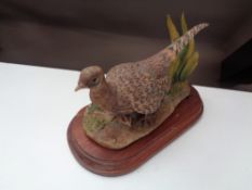 A Border Fine Arts figure of a female pheasant and chick on wooden stand