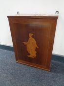 A continental mahogany wall cabinet with inlaid panel door