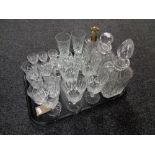 A tray of three lead crystal decanters and assorted drinking glasses