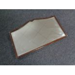 A shaped Edwardian mahogany framed mirror