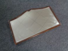 A shaped Edwardian mahogany framed mirror