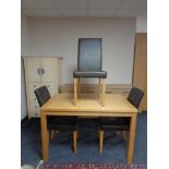 A contemporary kitchen table and three brown leather chairs