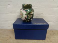 A W Moorcroft lidded ginger jar, flowers on olive green ground, height 15.