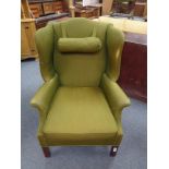 A 20th century wingback armchair upholstered in a olive green fabric