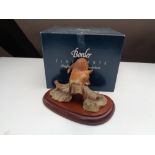 A Border Fine Arts figure of a fox on log, on wooden stand,