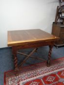 An Edwardian oak pull out table on barley twist legs