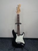 A Squier Stratocaster by Fender electric guitar on stand