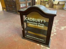 A mahogany wall mounted cabinet bearing Cadbury's advertisement