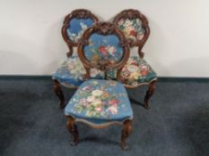 Three ornate Victorian dining chairs on cabriole legs in floral fabric