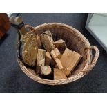 A wicker log basket containing logs and a set of brass embossed bellows