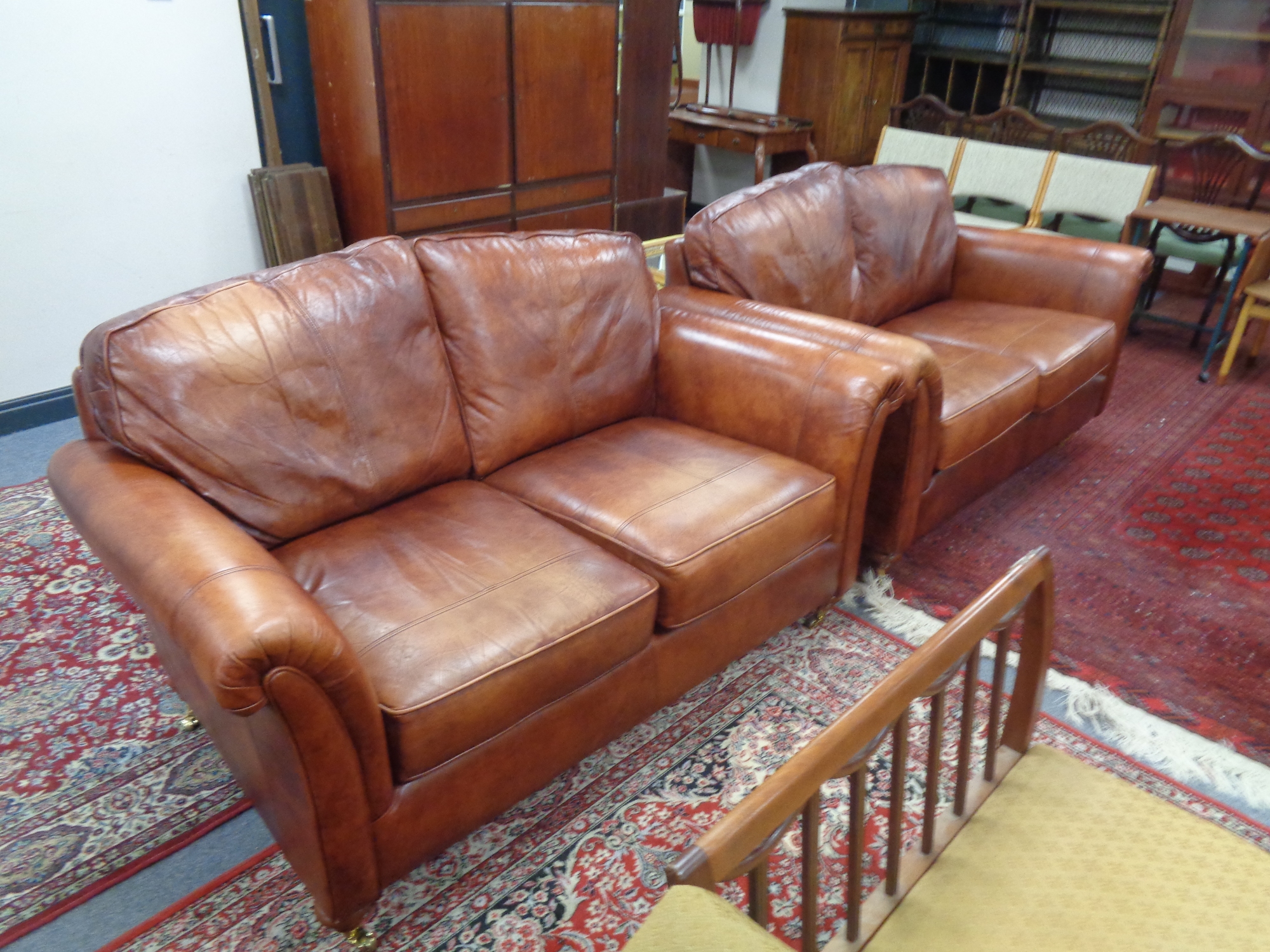 A pair of tan leather two seater settees