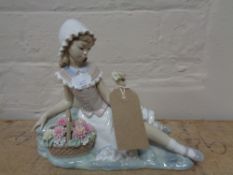 A Lladro figure of a girl seated with flowers, height 17 cm.