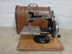 A mid 20th century child's Lead sewing machine in case