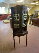 A double door mahogany corner display cabinet on stand bearing Fry's advertising