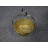 An antique brass jam pan with cast iron handle