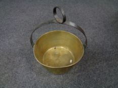 An antique brass jam pan with cast iron handle