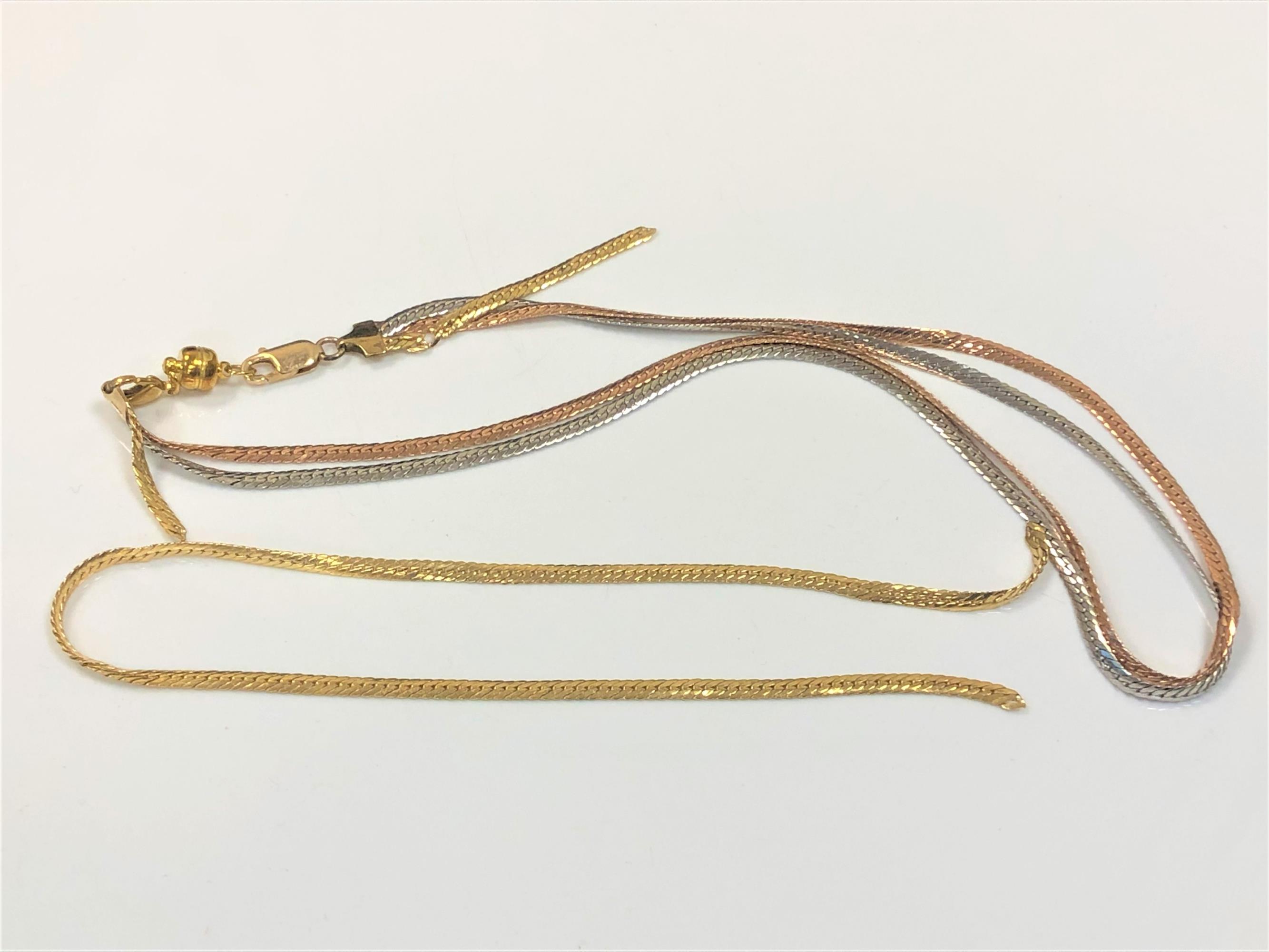 A tri-colour 9ct gold necklace (one strand broken) with non-gold magnetic clasp,