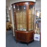 A late Victorian mahogany bowfronted display cabinet on raised legs